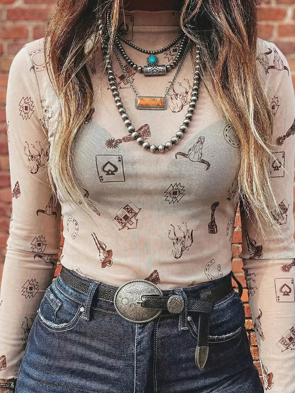 Sheer mesh mock neck shirt with western print, long sleeves, and a nude lining.