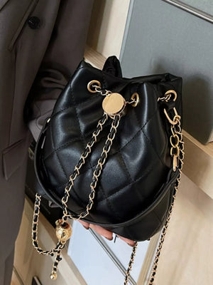 Chic quilted black bucket crossbody bag with gold chain strap and decorative charm.