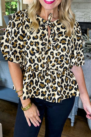 Leopard print peplum blouse with tie-neck and short puff sleeves.