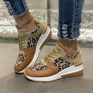 Leopard print lace-up sneakers with brown and tan color-block details and a white sole.