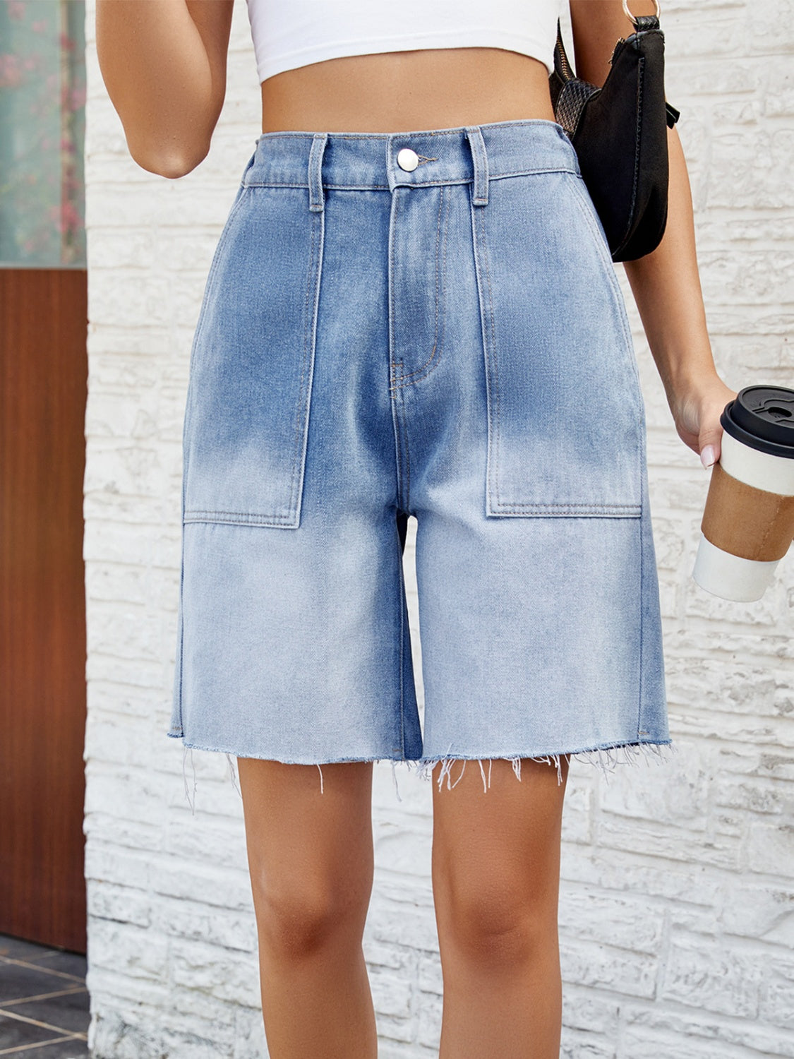 Light blue faded denim carpenter shorts with raw hem and large front pockets.