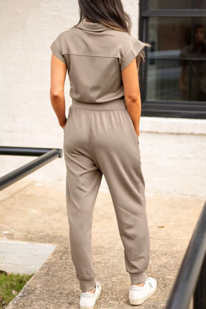 Collared zip front romper with cap sleeves and ankle cuffs in taupe.