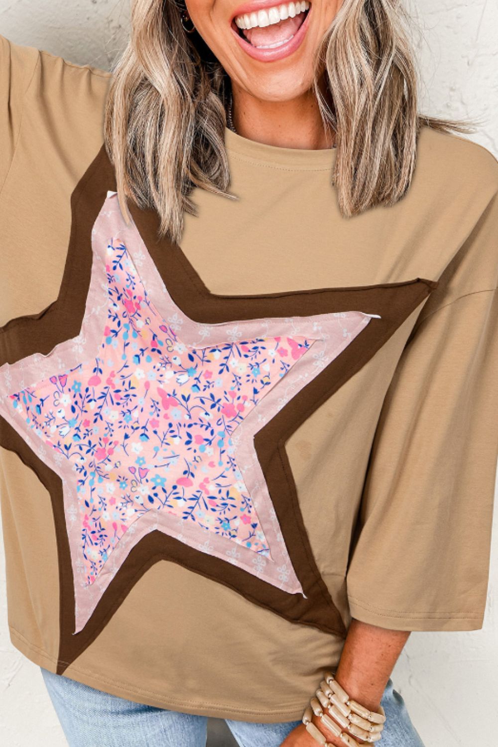 Tan cotton tee with a floral star patchwork detail and brown trim.