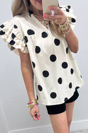Cream cotton v-neck shirt with black polka dots and ruffled short sleeves.