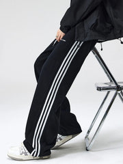 Black cotton sweatpants with white side stripes and drawstring waist.