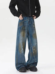 Men's plus-size wide-leg jeans in washed blue denim with paint splatters and distressed details.