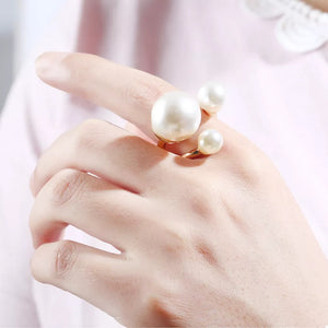Elegant gold-plated open ring with three pearls on a woman's finger.