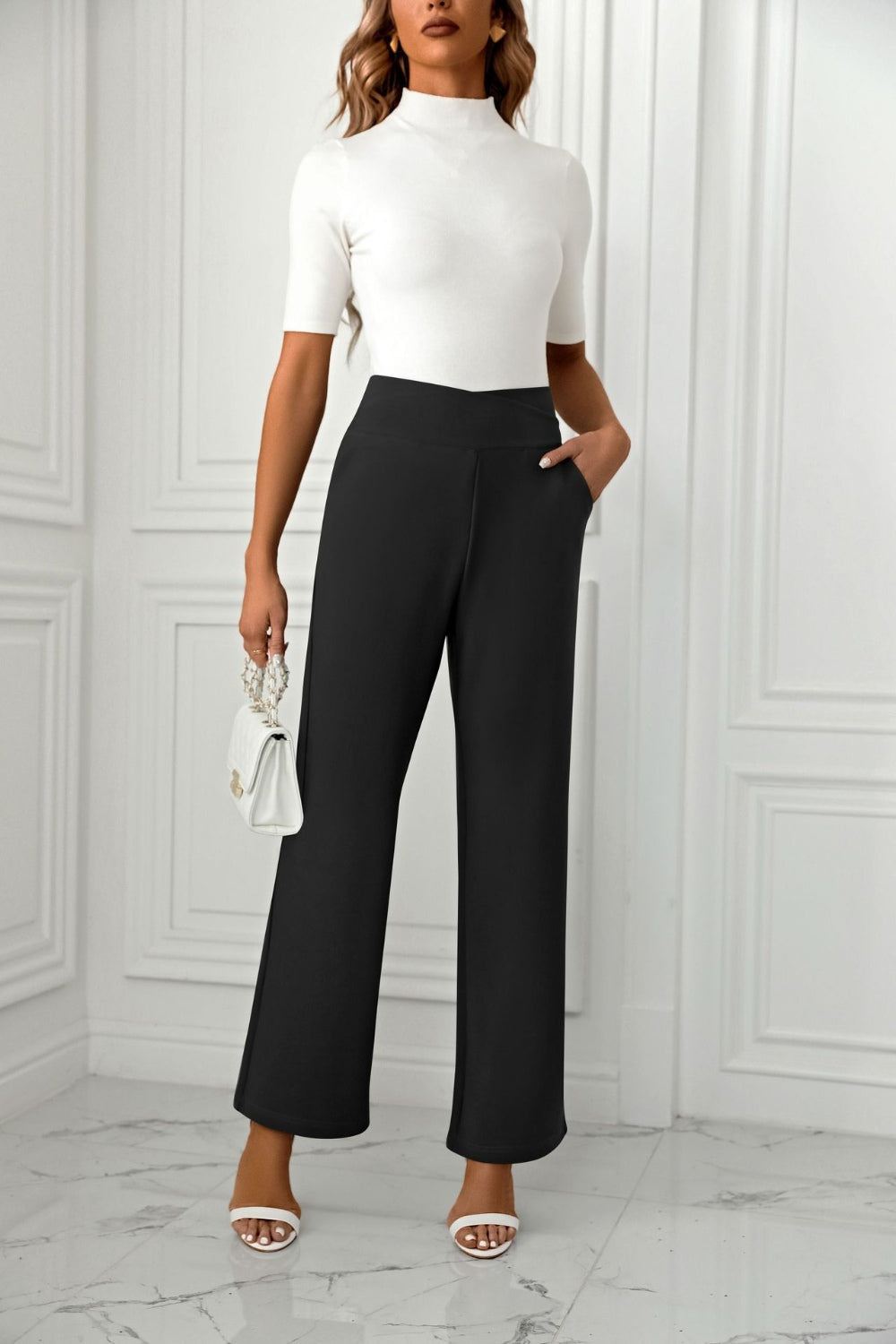 Black wide-leg trousers with a sculpted waist and pockets, styled with a white top and handbag.