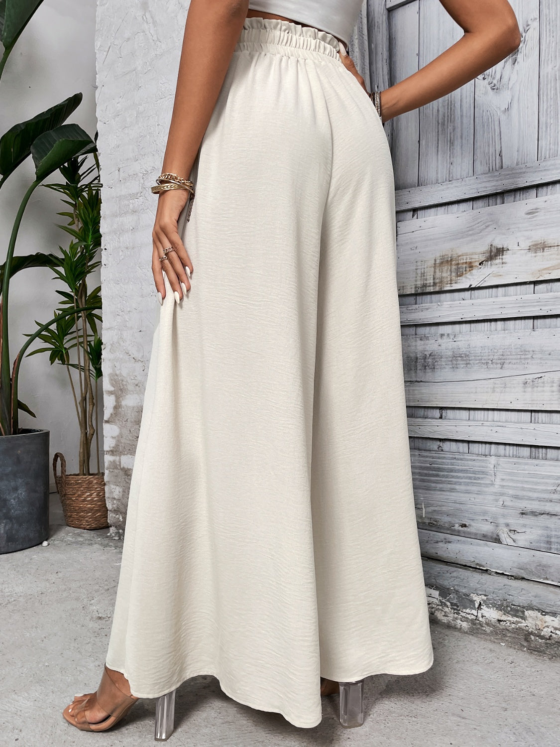 Beige ruffled waistline palazzo trousers with a wide leg.