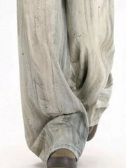Light vintage wash wide-leg denim trousers with distressed details and paint splatters.