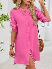 Fuchsia pink button-down shirt dress with band collar and rolled sleeves.