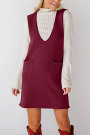 Burgundy knit sweater dress with deep V-neck and two front pockets, styled over a cream ribbed turtleneck.