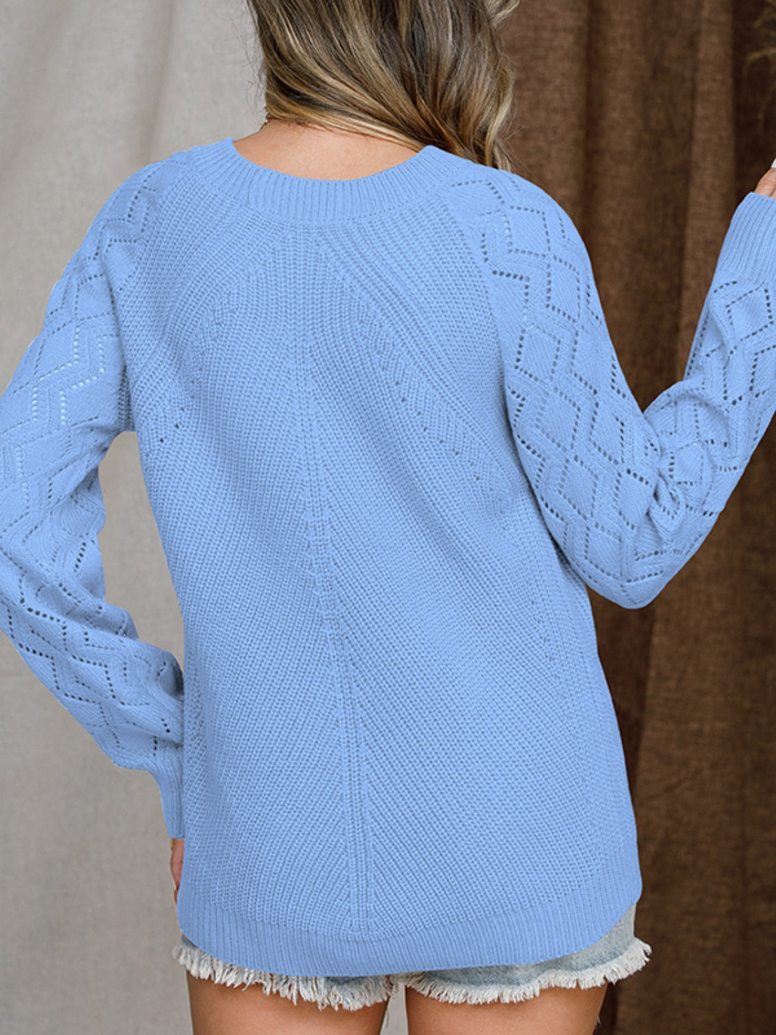 Blue diamond-cut raglan knit sweater with textured sleeves and neckline.