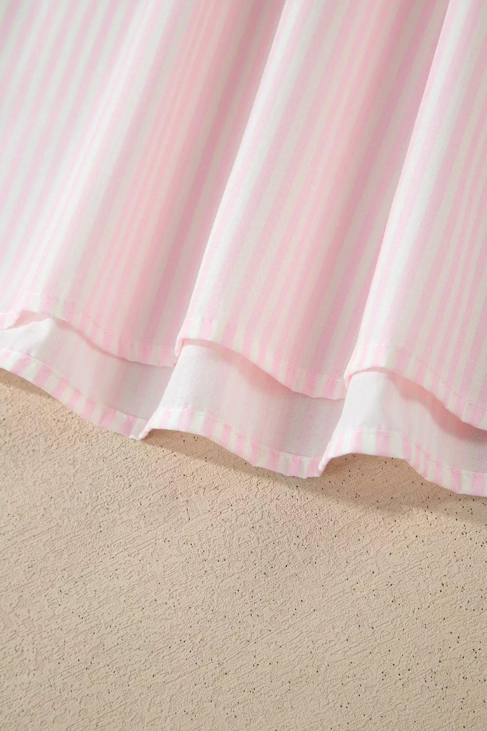 Pink and white striped polyester blouse with ruffled hem detail