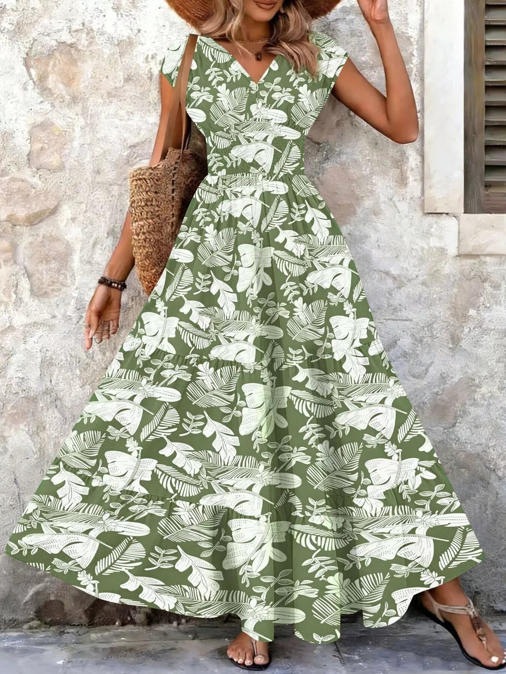 Green tiered maxi dress with white leaf print, V-neck, short sleeves, and smocked bodice.