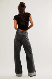 Cuffed wide-leg denim trousers in black with a relaxed fit and visible back pockets.