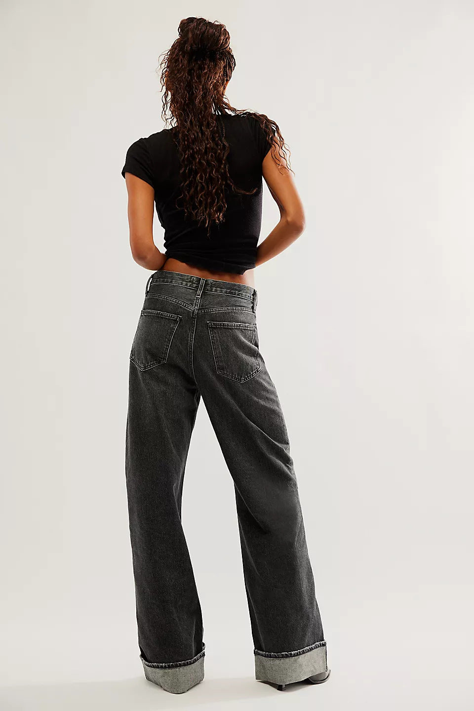 Cuffed wide-leg denim trousers in black with a relaxed fit and visible back pockets.