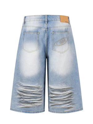 Men's light wash distressed wide-leg capri jeans with whiskering and embroidered back pocket detail.