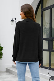 Black textured turtleneck sweater with long sleeves.