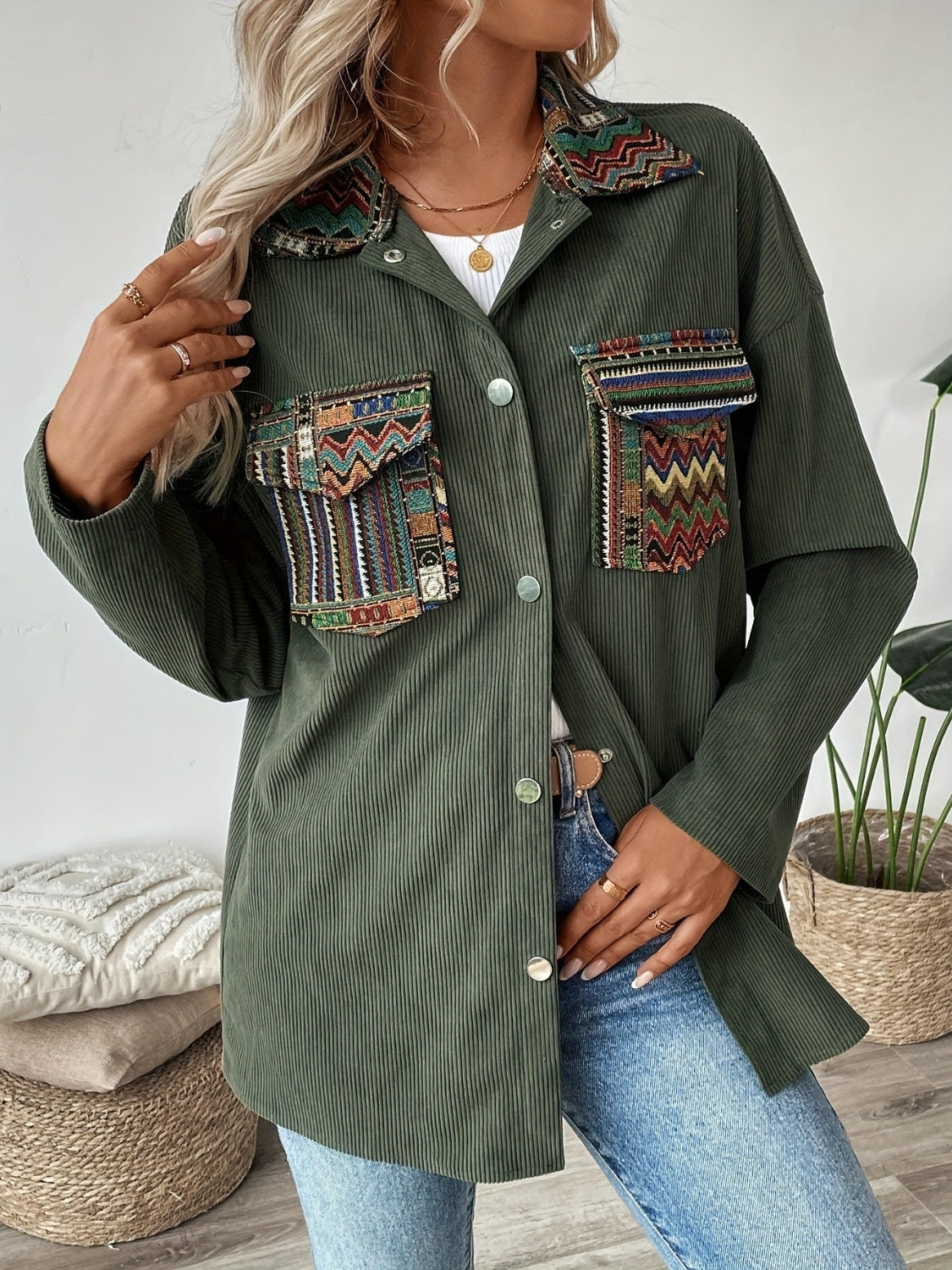 Army green corduroy overshirt with embroidered statement pockets and collar detail.