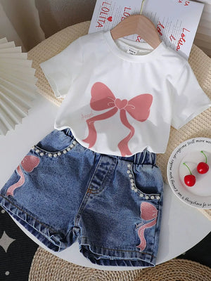 White tee with pink bow print and denim shorts with pearl trim and bow embroidery.