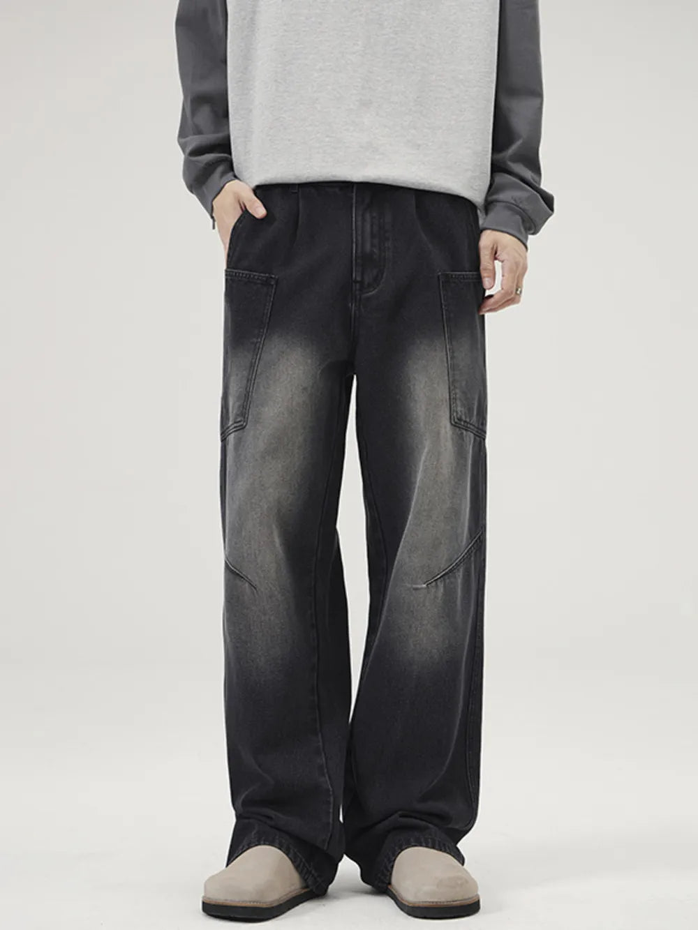 Relaxed fit washed wide-leg jeans in black with cargo pockets and a faded wash.