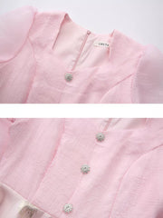 Pink midi dress with puff sleeves, square neckline, and jeweled buttons.