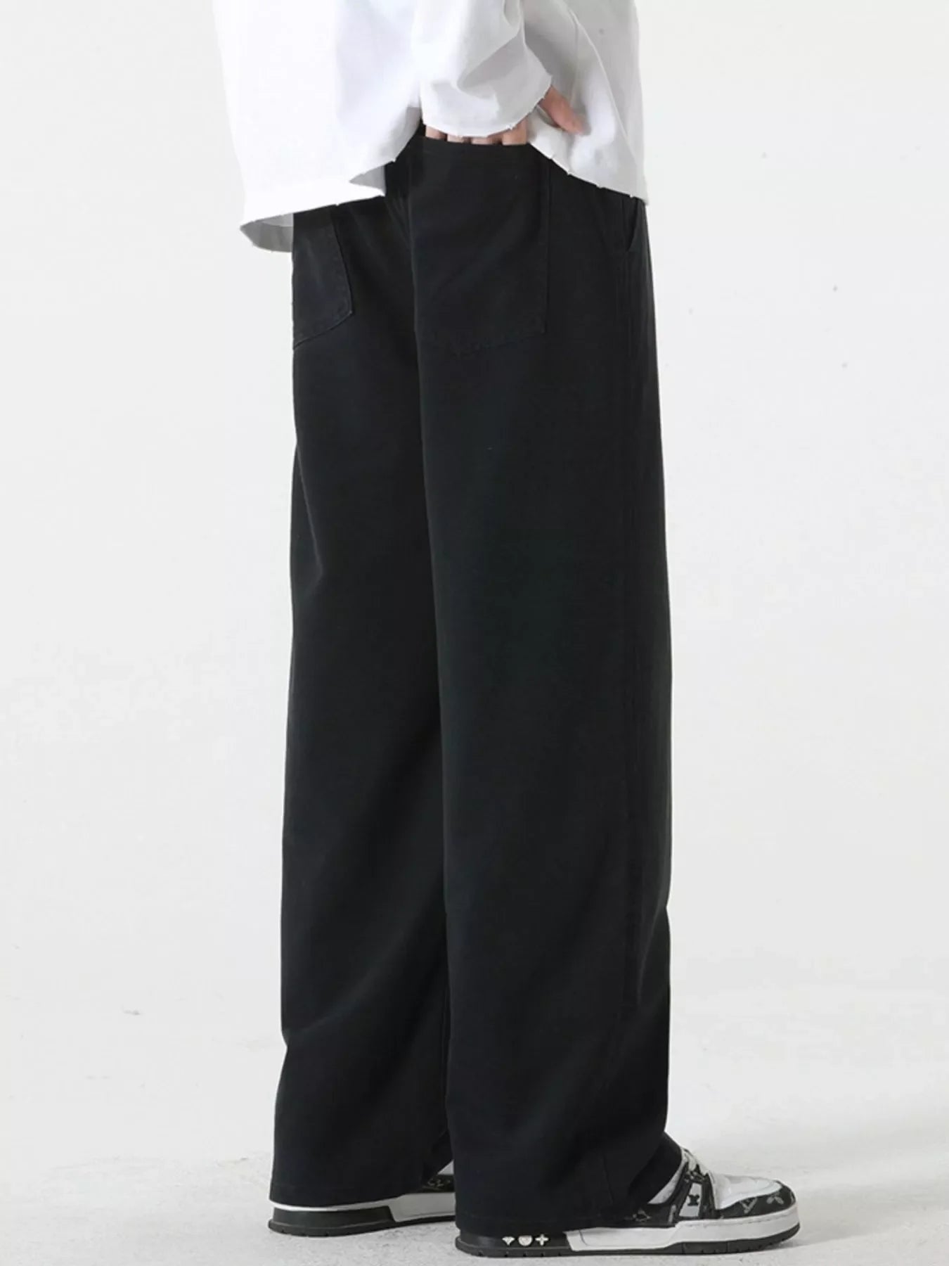 Black relaxed fit drawstring pants with side pockets, shown on a model.