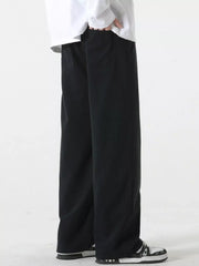 Black relaxed fit drawstring pants with side pockets, shown on a model.