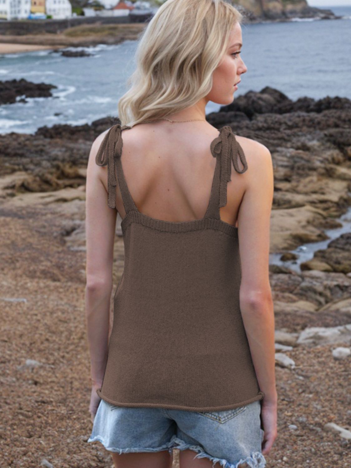 Brown knit tank top with tie straps and deep V-neck, styled with denim shorts.