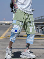 Color block utility cargo pants in light green and light blue with bold white text graphics and multiple pockets.