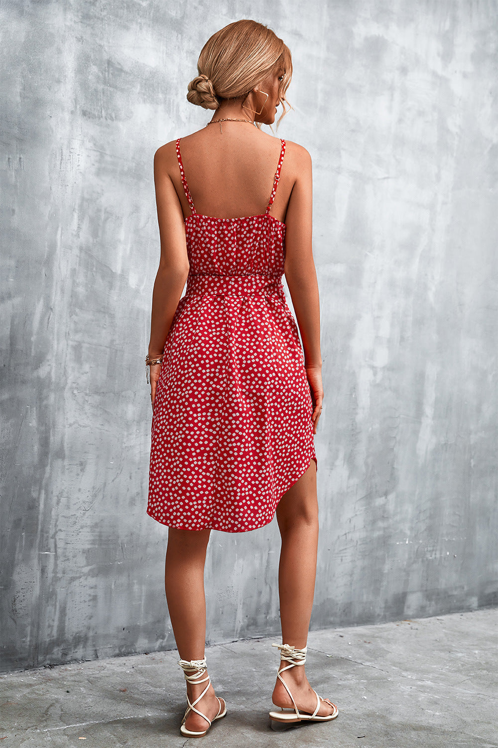 Red daisy print slip dress with spaghetti straps and tie waist, shown from the back.