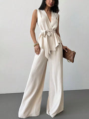 Sleeveless wrap top and wide-leg pants set in cream polyester with a tie waist.