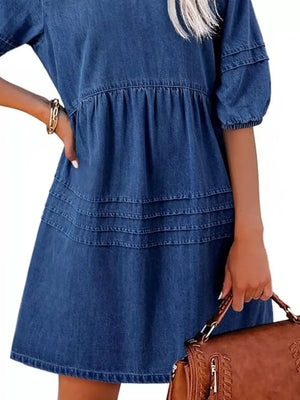 Denim mini dress with puff sleeves, tiered skirt, and smocked waist in blue.