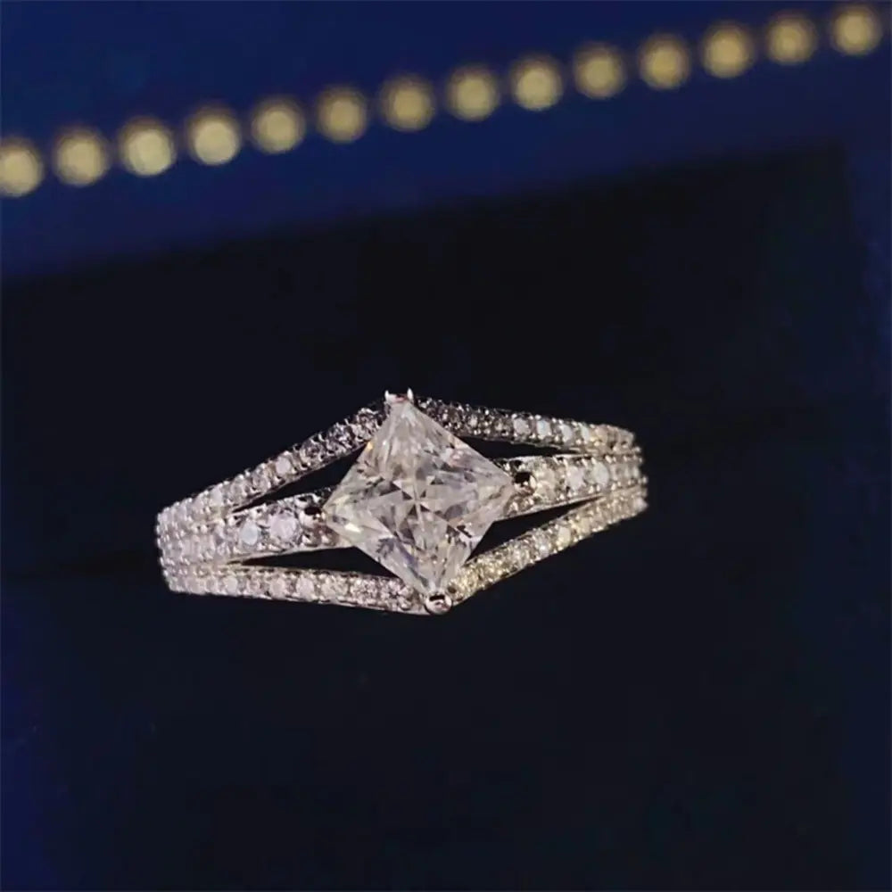 Princess cut moissanite ring in silver with split shank and pavé band.