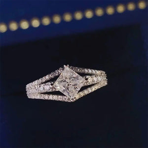 Princess cut moissanite ring in silver with split shank and pavé band.