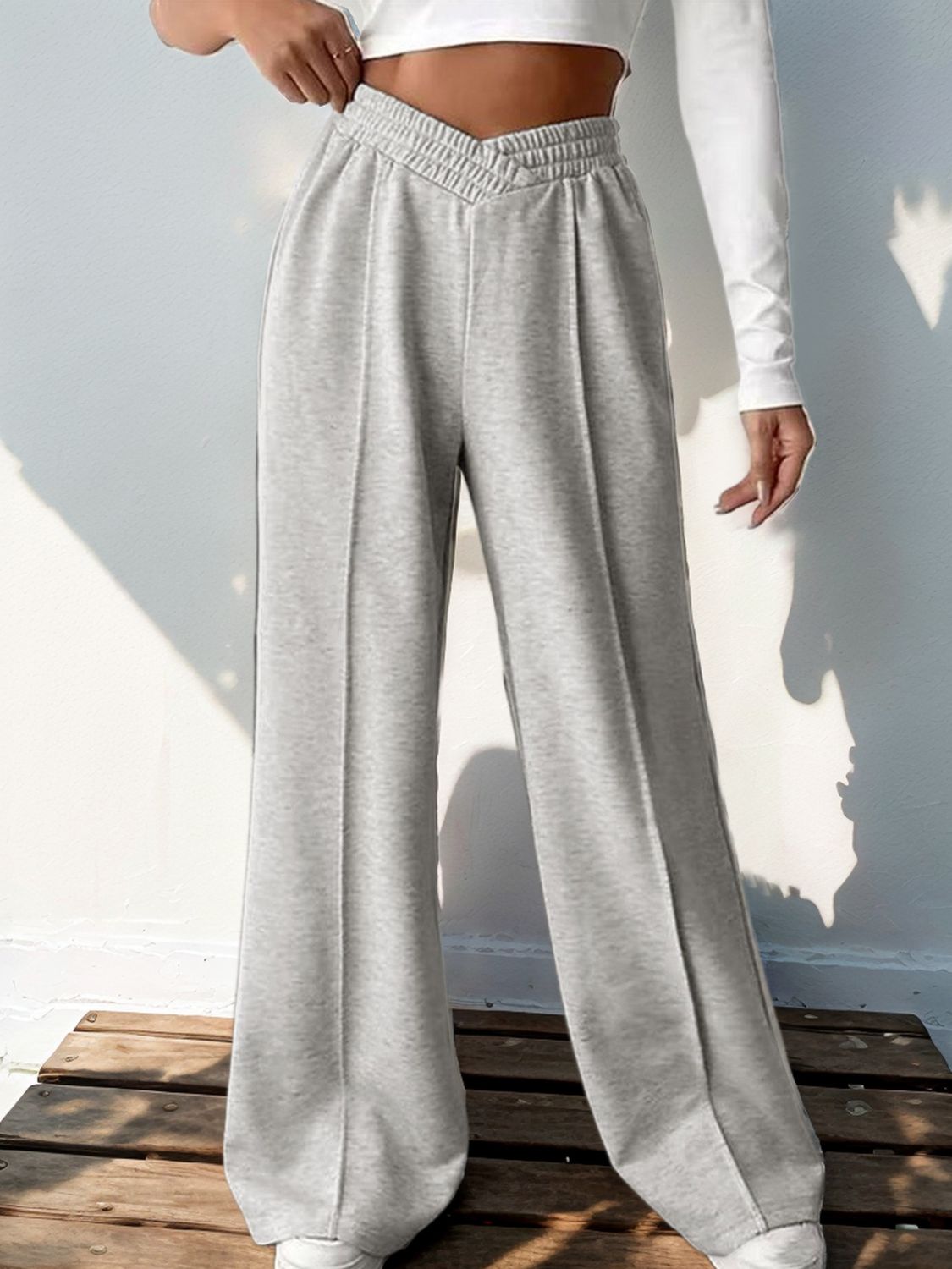 Light gray V-waistline pleated palazzo trousers with a comfortable, casual fit.