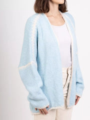 Light blue oversized cardigan with contrast trim and cream trim details.