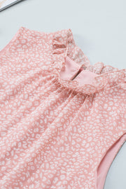 Blush pink sleeveless blouse with white leopard print and ruffled neckline.