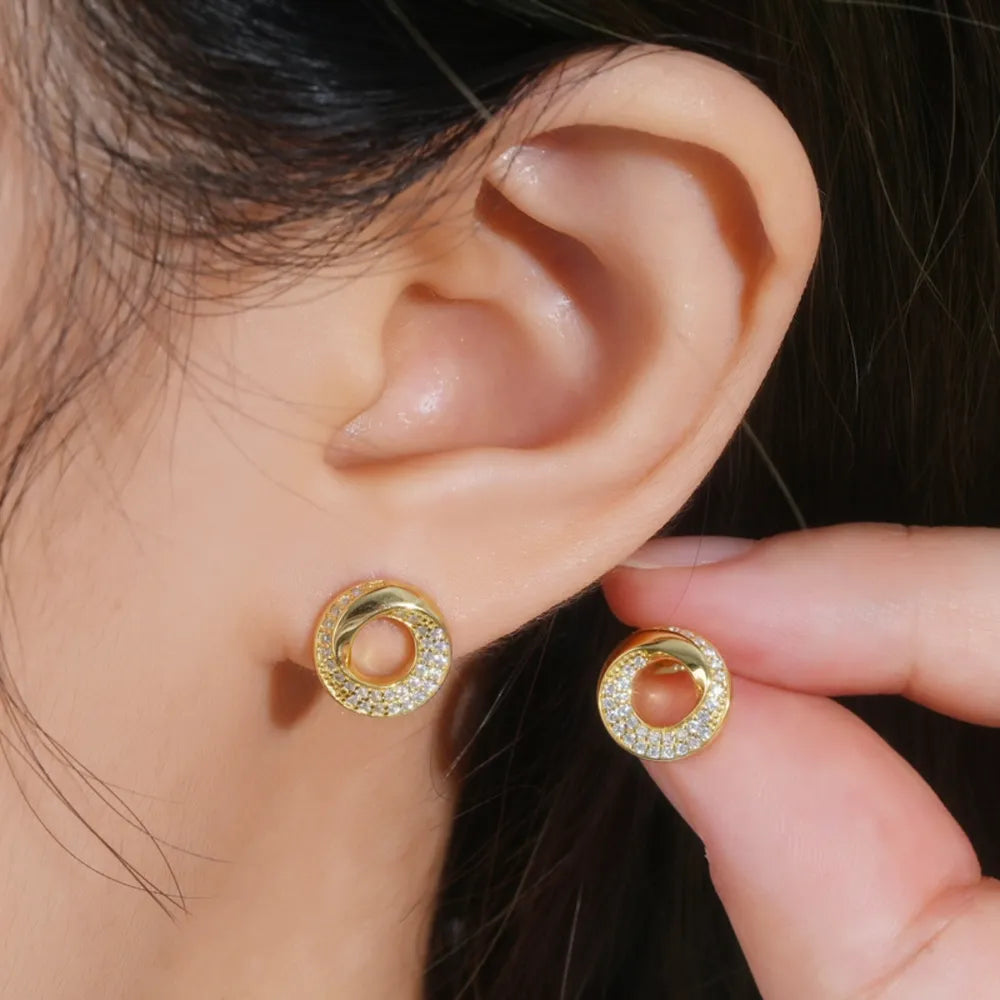 Gold pavé circle stud earrings with a twisted detail.