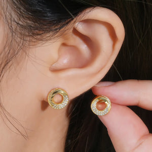 Gold pavé circle stud earrings with a twisted detail.