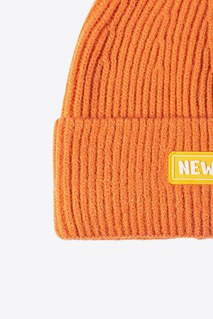 Orange ribbed acrylic beanie with yellow New York patch detail