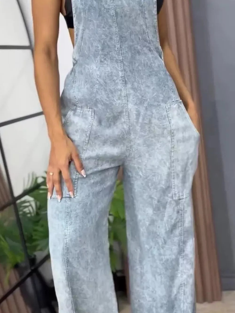 Vintage wash wide-leg denim overalls in light blue with front pockets and a relaxed fit.