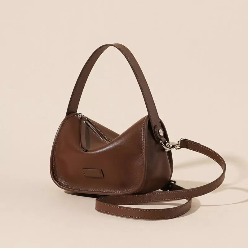 Caramel leather crossbody bag with adjustable straps and silver hardware.