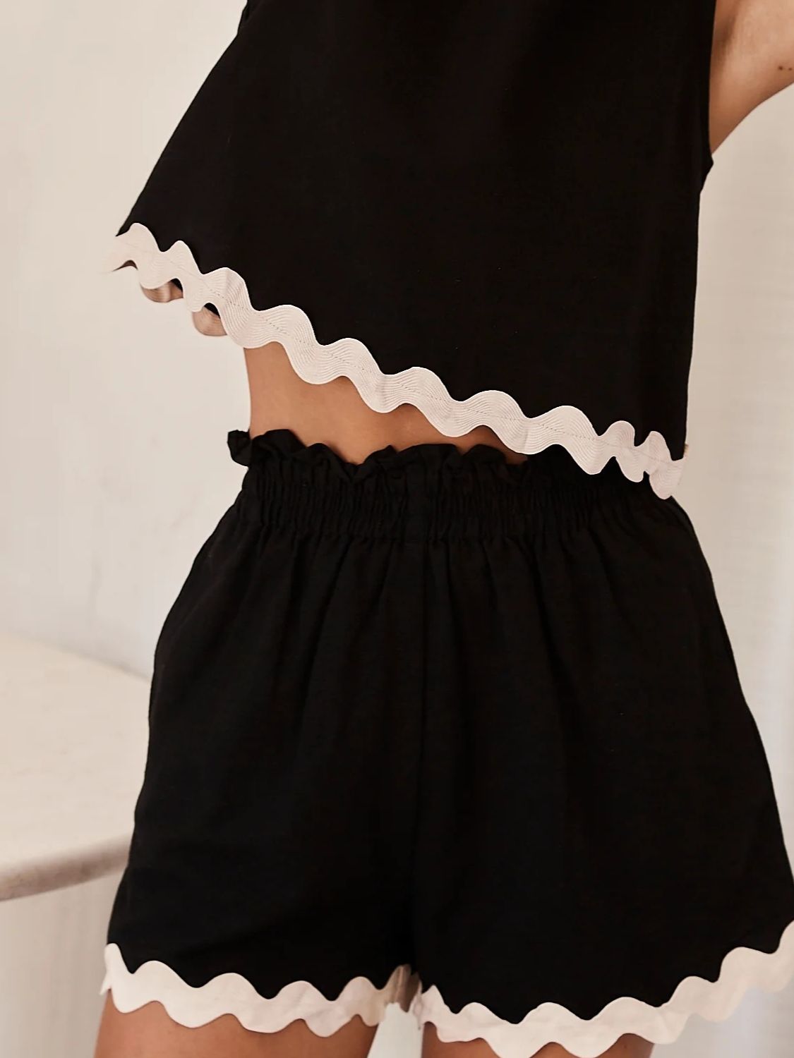 Black linen tank and shorts set with scalloped white trim and smocked waist.
