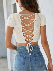 Cream crochet crop top with short sleeves and a lace-up back detail.