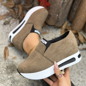 Dark brown round toe platform slip-on sneakers with white soles and black accents.