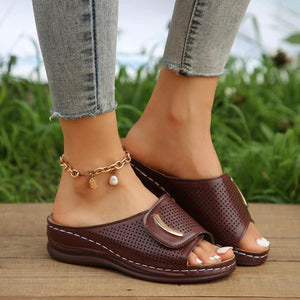 Burgundy perforated wedge sandals with gold accent and white stitching.