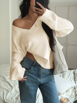 Effortless V-neck knit top in white with bell sleeves, styled with jeans.