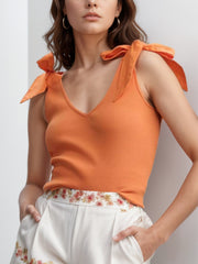 Orange ribbed knit tank top with v-neck and bow shoulder straps